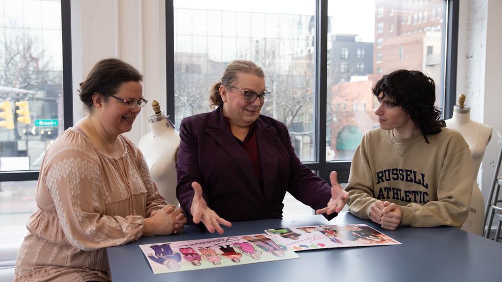 Dress for Success client Francesca Schumann (center), with CCAD students Amy Magnus (left) and Alex Baum, looks at sketches created by the students for Schumann.
